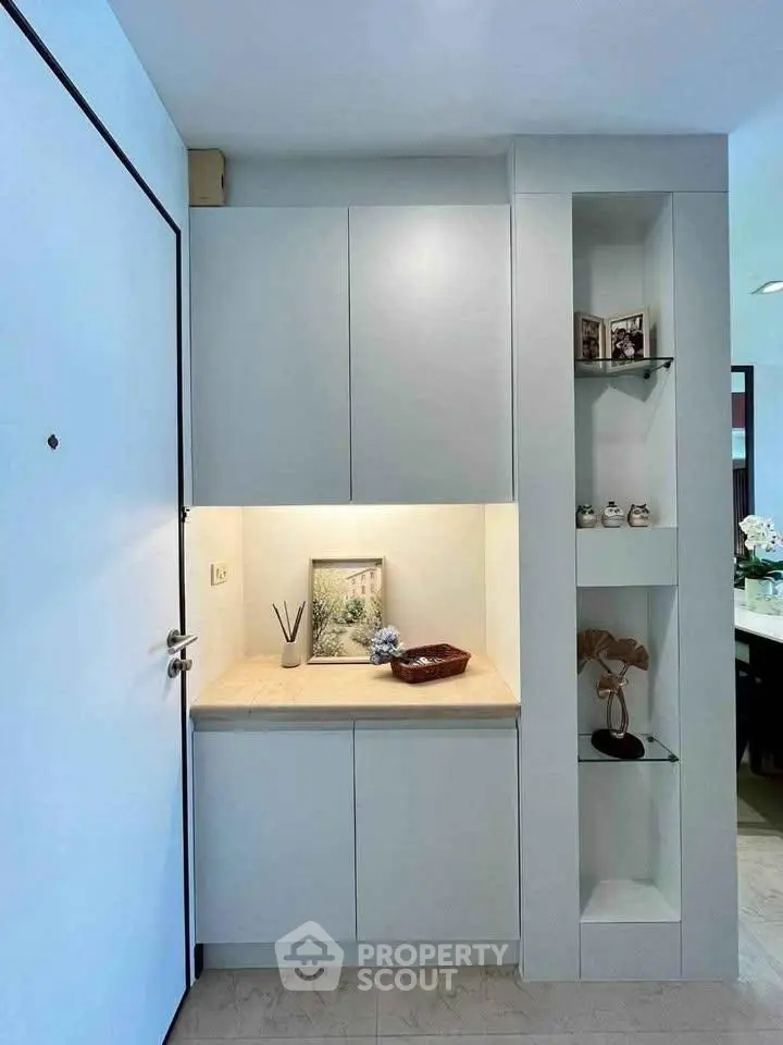 Modern entryway with sleek cabinetry and decorative shelving