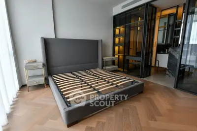 Modern bedroom with stylish bed frame and glass partition in luxury apartment