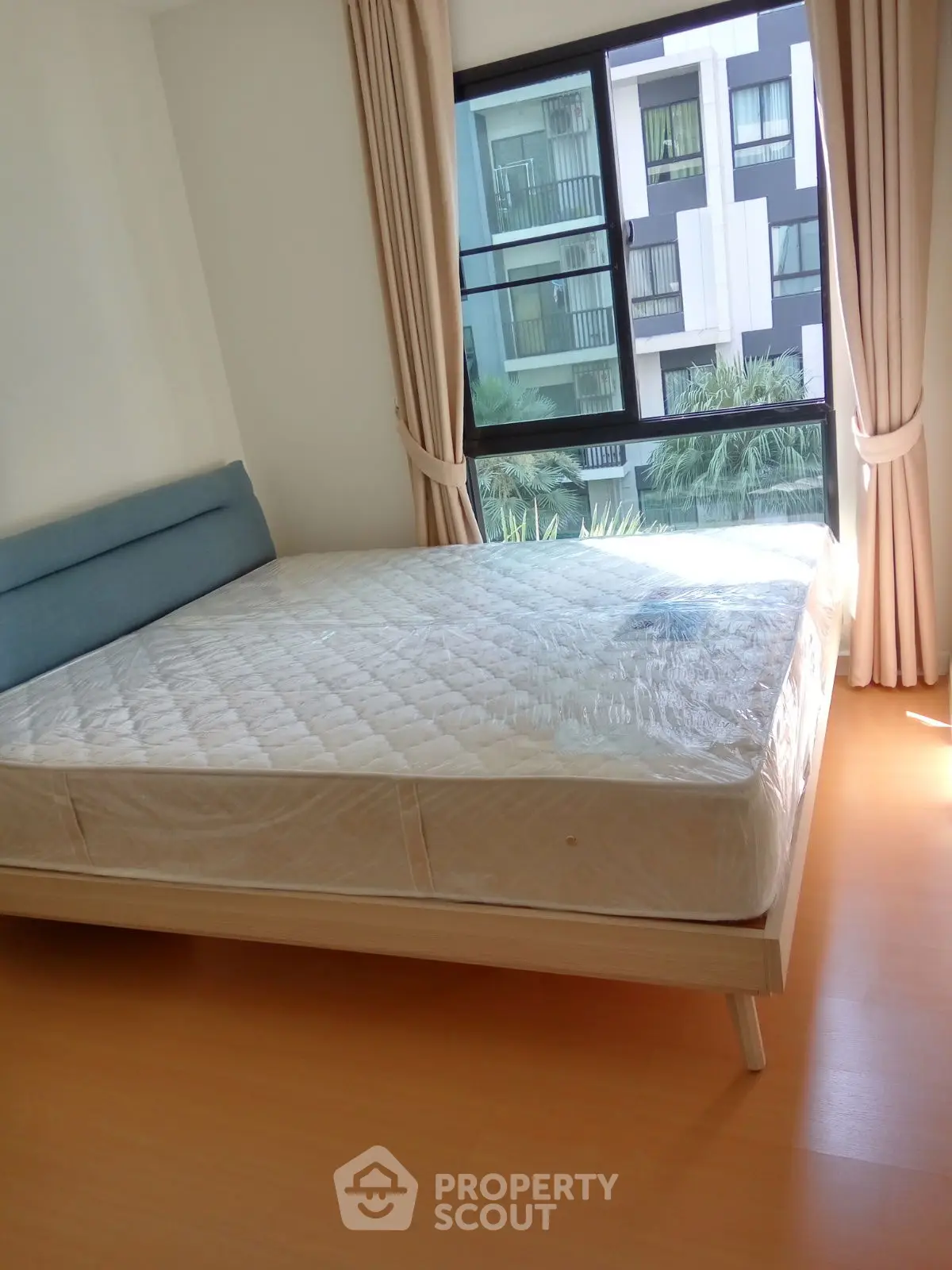 Bright bedroom with large window and modern bed in urban apartment