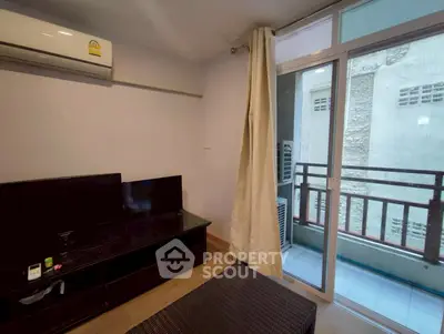 Cozy living room with balcony access and modern entertainment setup