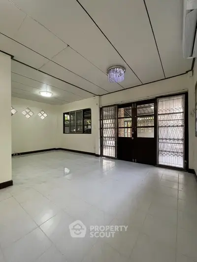 Spacious living room with elegant lighting and large windows for natural light.