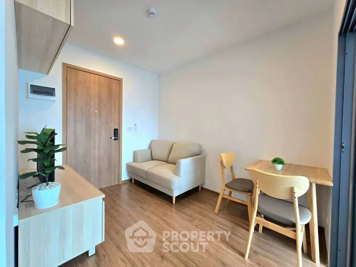 Cozy living room with modern furniture and wooden flooring in a bright apartment.