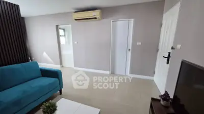 Modern living room with blue sofa and air conditioning unit