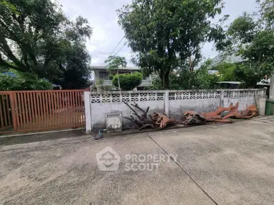 Charming suburban home with lush greenery and secure gated entrance.