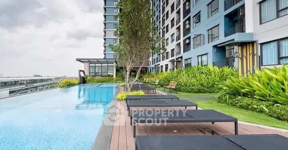 Luxurious apartment building with stunning poolside and lush garden area.