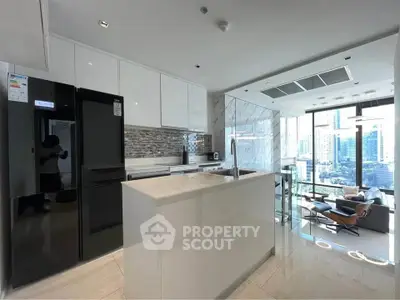 Modern kitchen with sleek appliances and open layout in a high-rise apartment with city view.