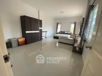 Spacious bedroom with modern furniture and ample natural light