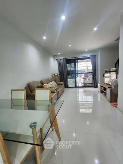 Spacious modern living room with glass dining table and cozy seating area