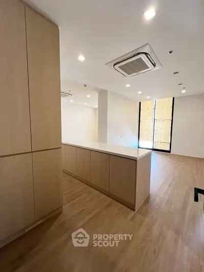 Spacious modern kitchen with sleek wooden cabinetry and ample natural light.