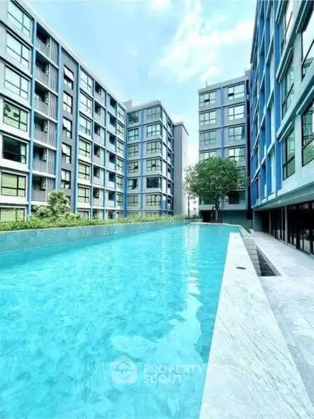 Modern apartment complex with a stunning outdoor pool and sleek architectural design.