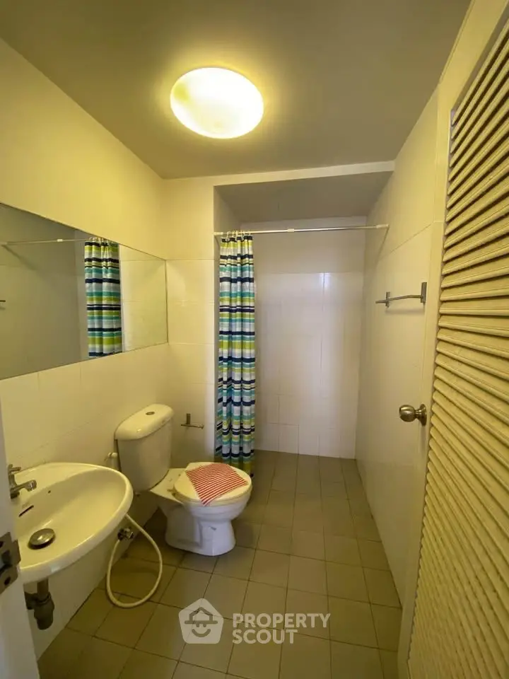 Spacious bathroom with modern fixtures and colorful shower curtain