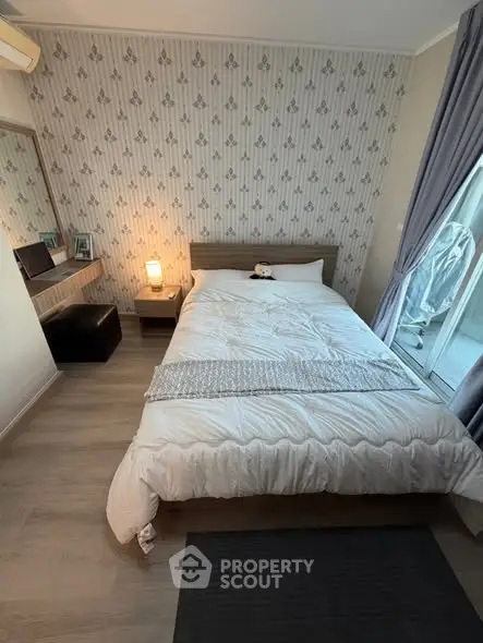 Cozy bedroom with stylish wallpaper and natural light, perfect for relaxation and comfort.