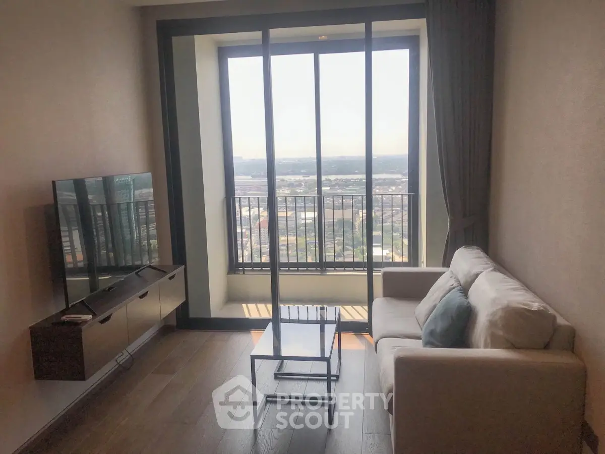 Modern living room with large window offering stunning city view, cozy sofa, and sleek TV setup.