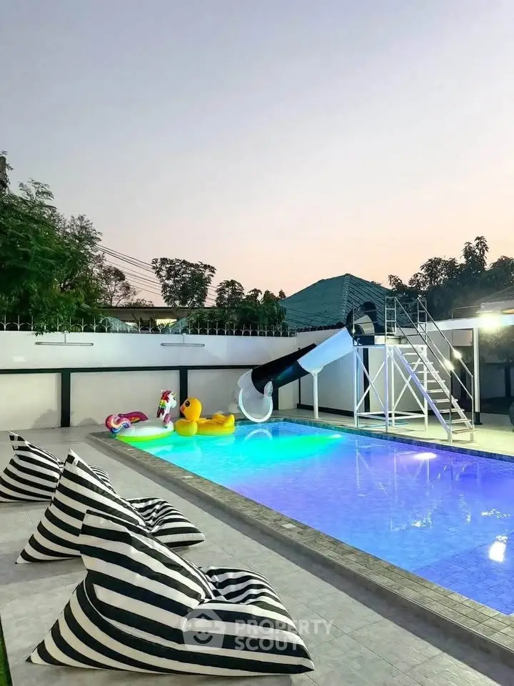 Luxurious pool area with slide and stylish seating, perfect for relaxation and entertainment.