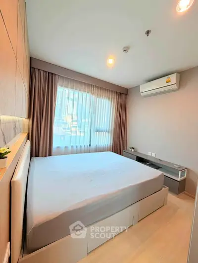 Modern bedroom with large window and air conditioning in stylish apartment