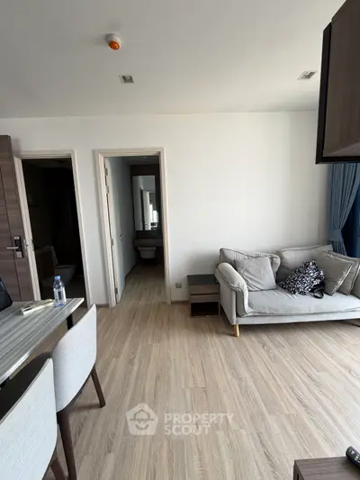 Modern living room with cozy sofa and elegant dining area in a stylish apartment.