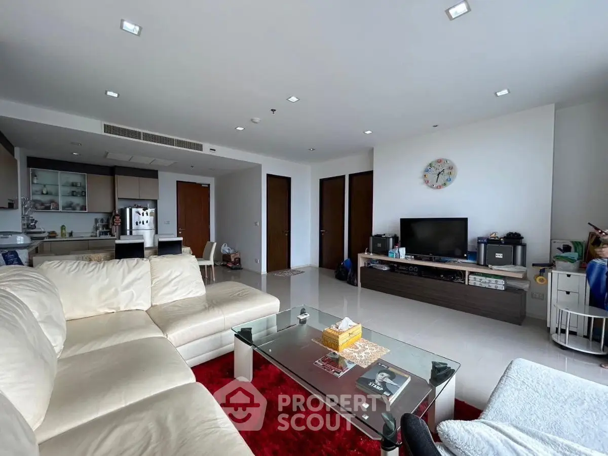 Spacious modern living room with sleek furniture and open kitchen layout, perfect for family gatherings.