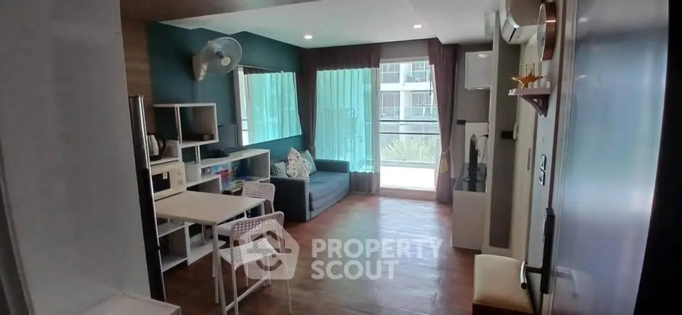 Modern living room with balcony, stylish decor, and natural light