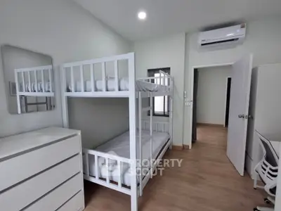 Modern bedroom with bunk beds and air conditioning in a bright, minimalist design.