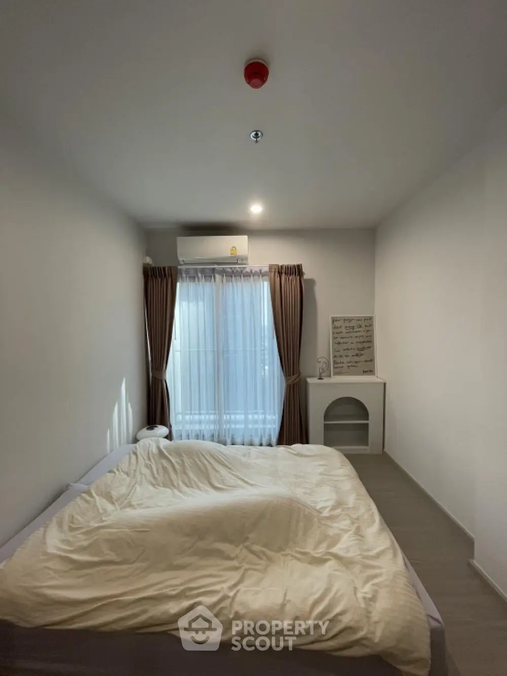 Cozy bedroom with natural light and modern decor, featuring a comfortable bed and stylish curtains.