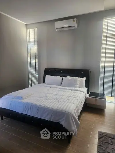 Modern bedroom with sleek design, featuring a comfortable bed and air conditioning, perfect for relaxation.
