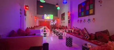 Vibrant lounge area with colorful lighting and cozy seating, perfect for relaxation and entertainment.