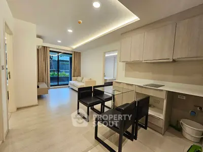 Modern open-plan living room with sleek kitchen and balcony view
