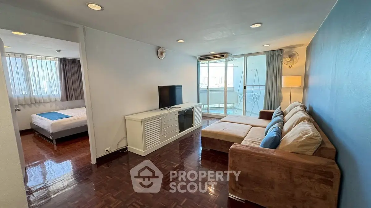 Spacious living room with modern decor and adjacent bedroom in a stylish apartment.