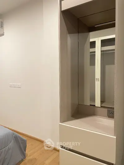 Modern bedroom with built-in wardrobe and wooden flooring
