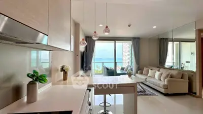 Modern open-plan living room with ocean view, stylish decor, and natural light.