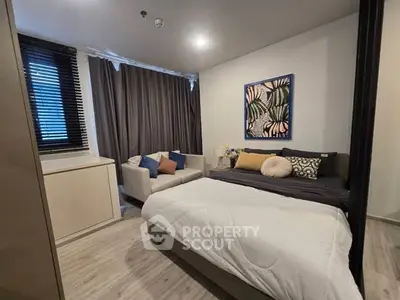 Cozy bedroom with modern decor, featuring a comfortable bed and stylish seating area.
