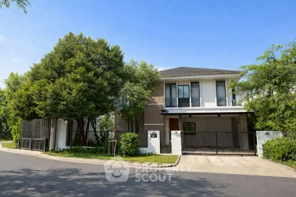 Stunning modern two-story house with lush greenery and spacious driveway in a serene neighborhood.