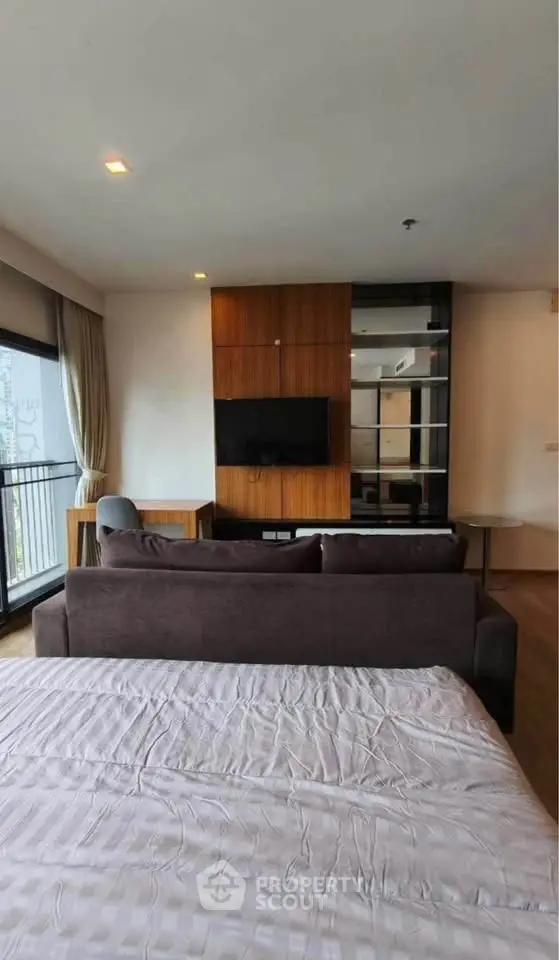 Modern studio apartment with stylish decor and balcony view
