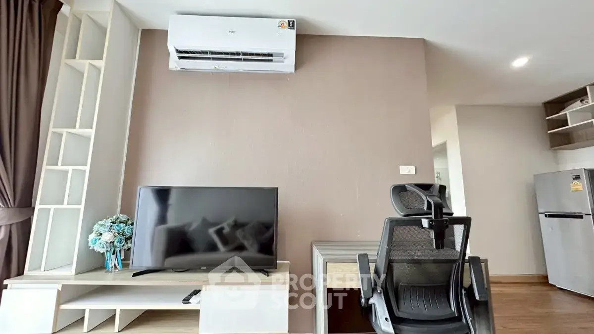 Modern living room with air conditioning, TV, and ergonomic chair in a stylish apartment.