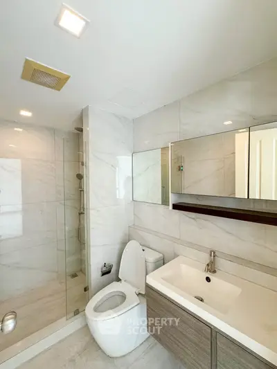 Modern bathroom with sleek design, featuring a glass shower, elegant sink, and contemporary fixtures.