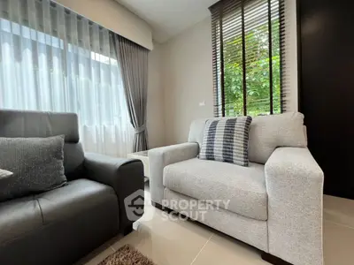 Modern living room with stylish furniture and large window, perfect for relaxation and comfort.