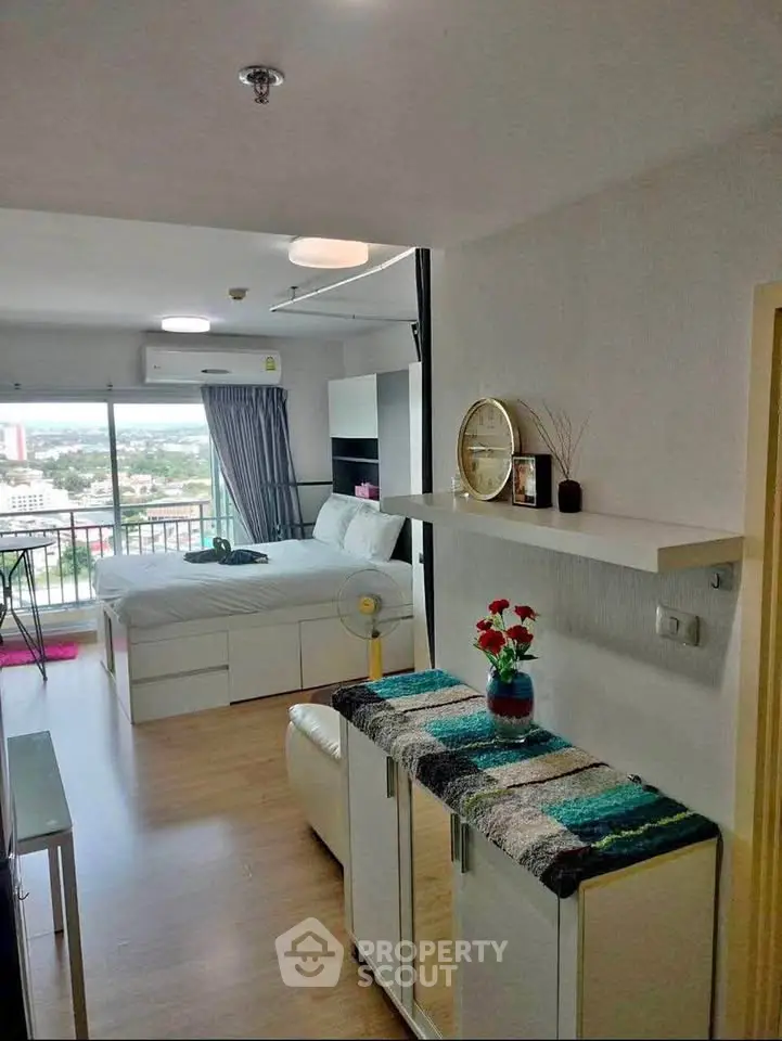 Modern studio apartment with balcony and city view, featuring stylish decor and natural light.