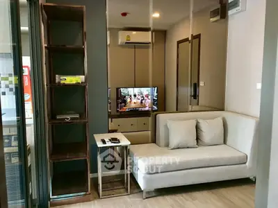 Modern living room with sleek furniture and wall-mounted TV in a cozy apartment.
