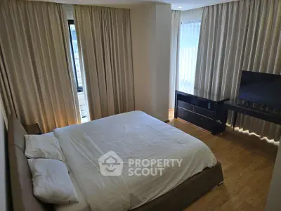 Modern bedroom with elegant curtains and sleek furniture, perfect for a cozy retreat.