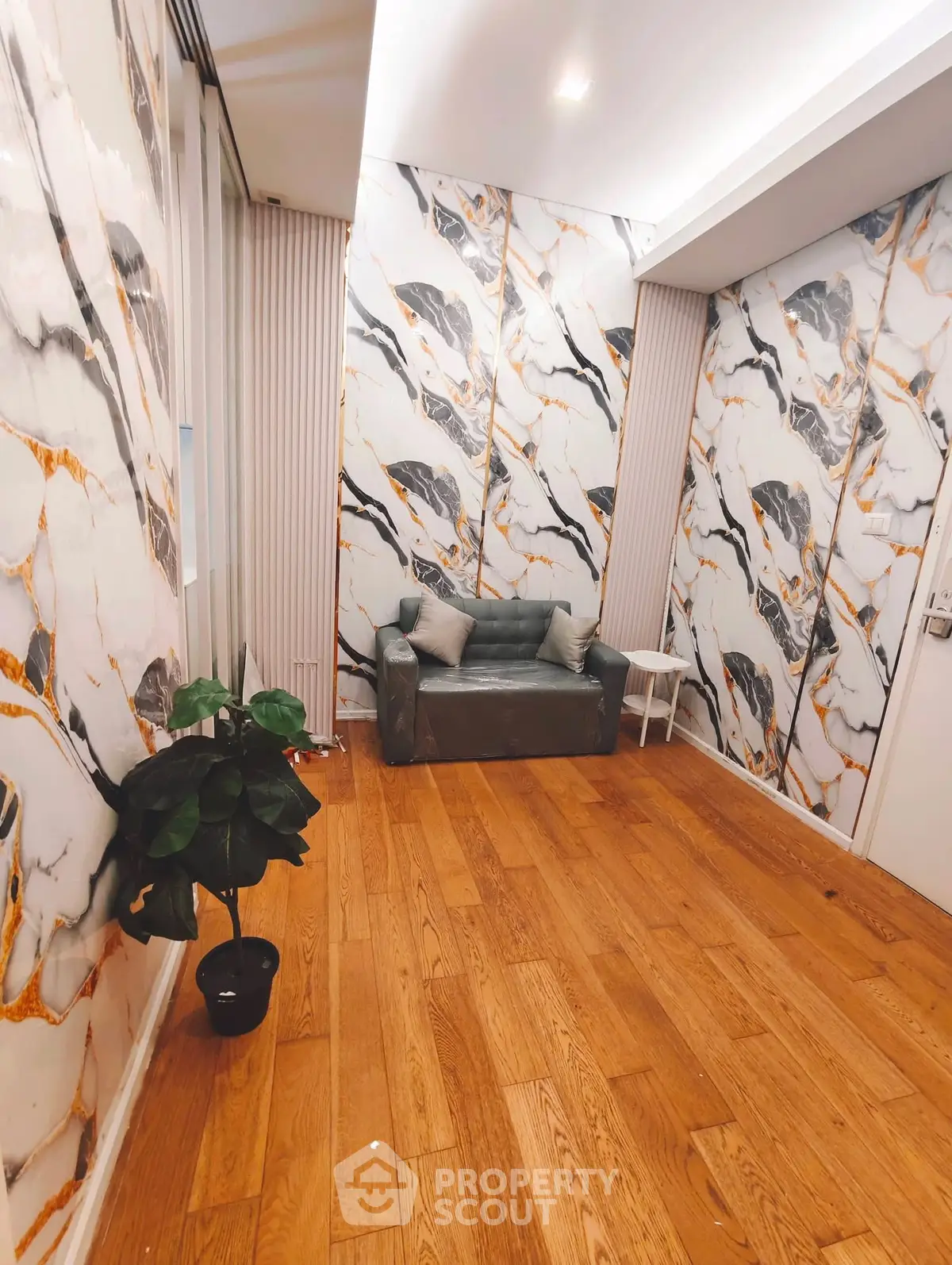 Stylish interior with marble-patterned walls and cozy seating area, perfect for modern living.