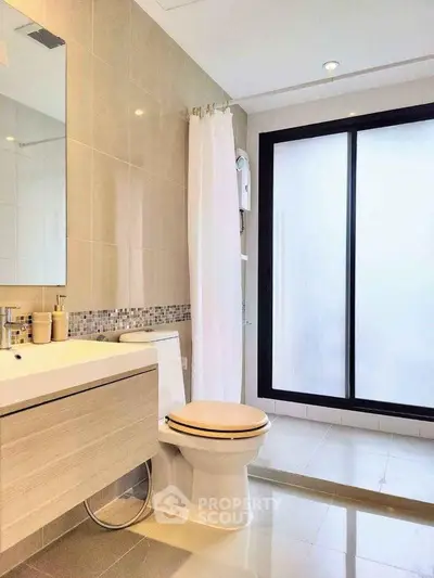 Modern bathroom with sleek design, featuring a large frosted glass window and stylish fixtures.