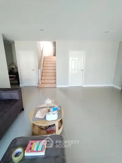 Spacious living room with modern decor and sleek staircase