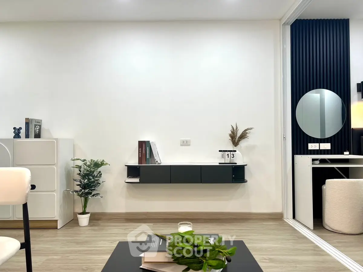 Modern living room with sleek furniture and minimalist decor, featuring a wall-mounted shelf and stylish accents.