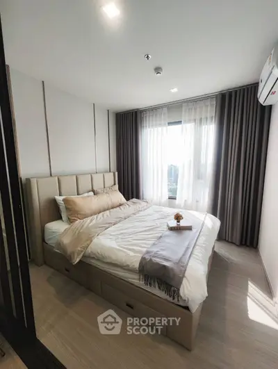 Modern bedroom with stylish decor and large window offering natural light