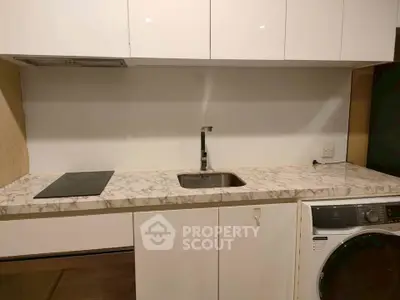 Modern kitchen with marble countertop and built-in appliances, featuring a sleek design.