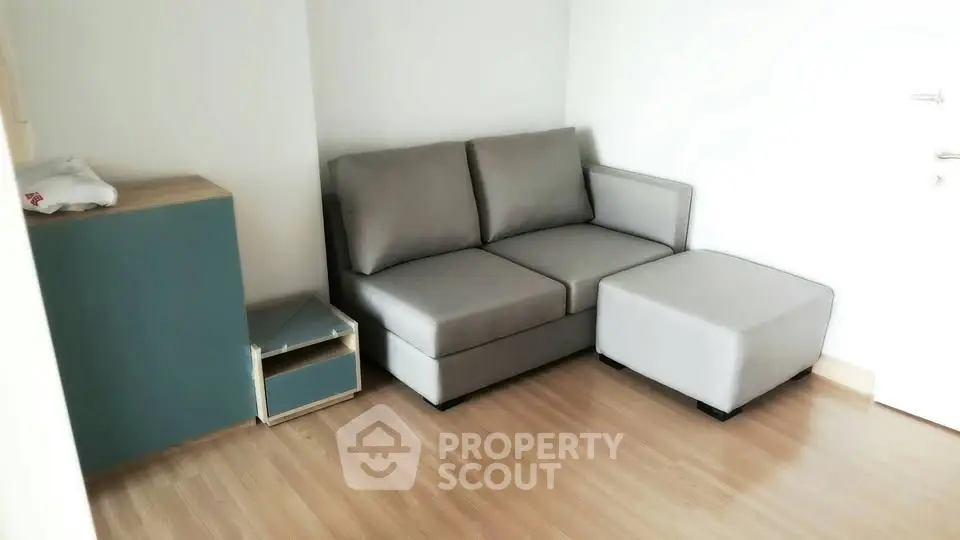 Modern living room with sleek gray sofa and wooden flooring, perfect for cozy relaxation.
