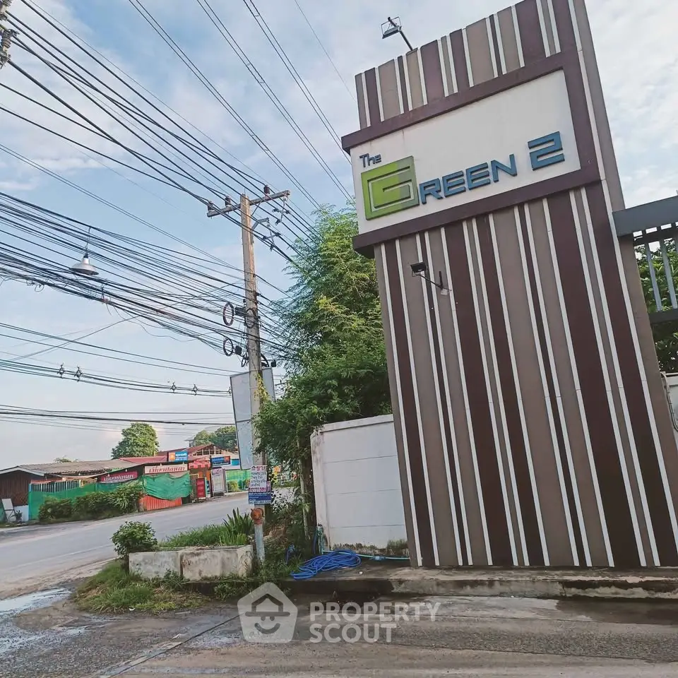 Modern entrance of The Green 2 with sleek design and street view, showcasing urban living.