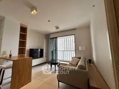 Modern living room with balcony access, featuring sleek furniture and natural light.