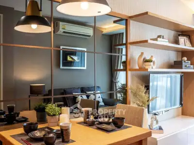 Modern living room with stylish decor and dining area, featuring elegant lighting and contemporary furniture.