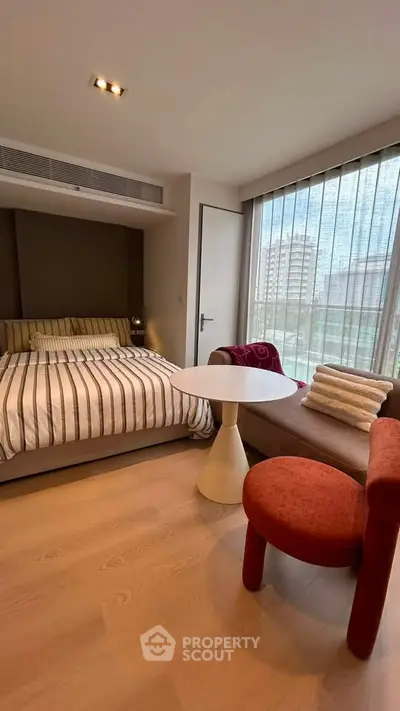 Modern bedroom with stylish furniture and large window offering city view